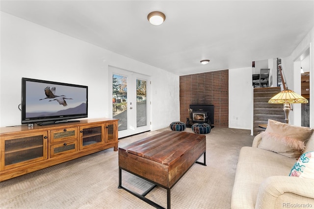 living room featuring light colored carpet and a wood stove