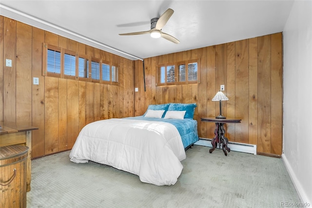 bedroom featuring light colored carpet, a baseboard radiator, ceiling fan, and wooden walls