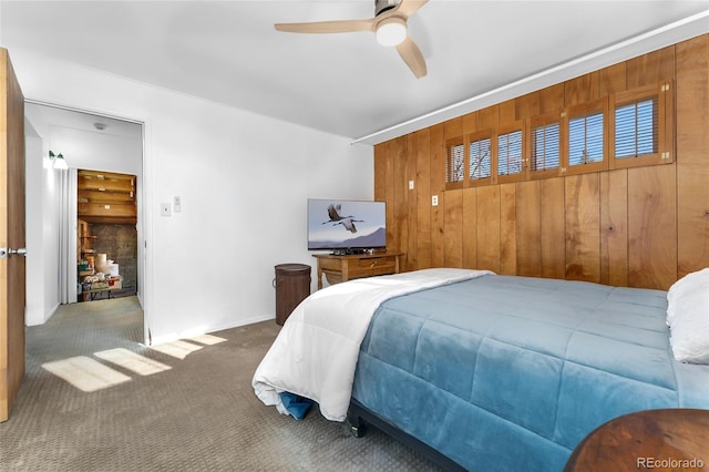 bedroom with carpet flooring, ceiling fan, and wood walls