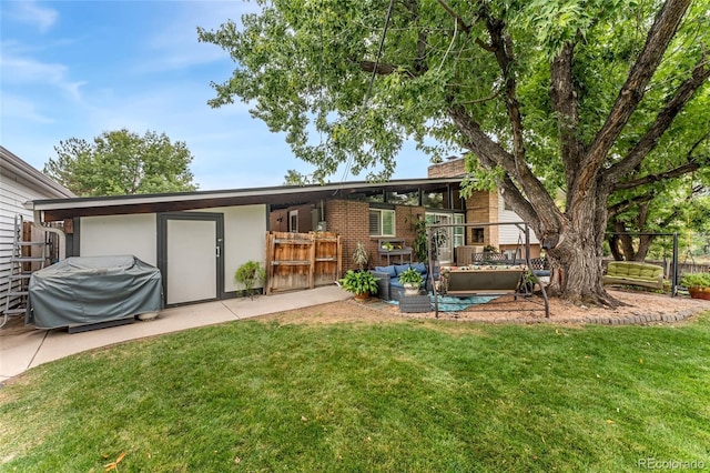 rear view of property with an outdoor living space and a yard