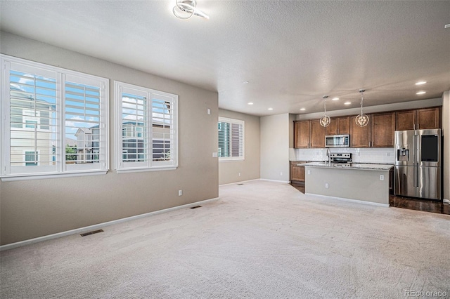 17187 E Cedar Gulch Dr, Parker, CO 80134 - kitchen with stainless steel appliances, open floor plan, carpet flooring, a center island with sink, and recessed lighting