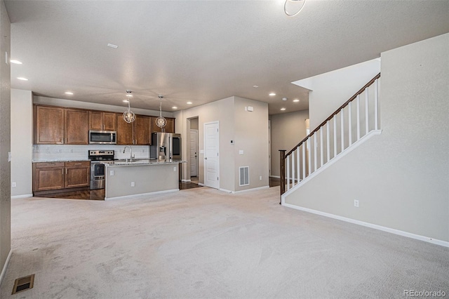 17187 E Cedar Gulch Dr, Parker, CO 80134 - kitchen with appliances with stainless steel finishes, open floor plan, carpet, recessed lighting, and an island with sink