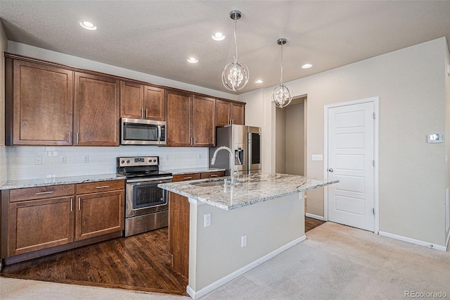 17187 E Cedar Gulch Dr, Parker, CO 80134 - kitchen featuring stainless steel appliances, a kitchen island with sink, light stone countertops, recessed lighting, and backsplash