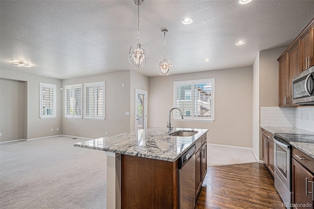 17187 E Cedar Gulch Dr, Parker, CO 80134 - kitchen with stainless steel appliances, a textured ceiling, dark carpet, light stone countertops, and a kitchen island with sink