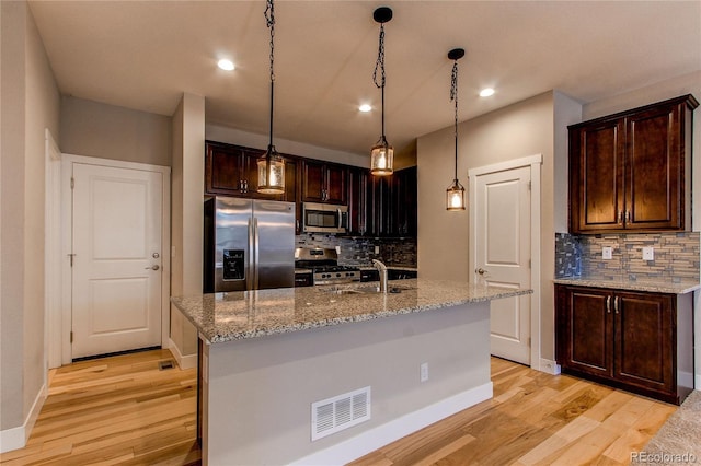 767 Robert St, Longmont, CO 80503 - kitchen with appliances with stainless steel finishes, recessed lighting, backsplash, light wood-style flooring, and light stone countertops