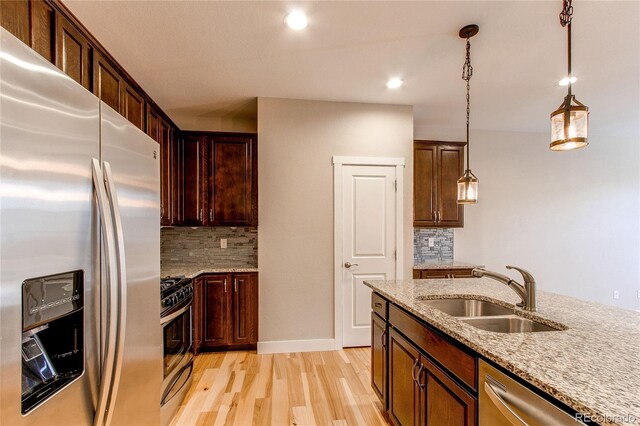 767 Robert St, Longmont, CO 80503 - kitchen featuring appliances with stainless steel finishes, a sink, light wood-type flooring, backsplash, and recessed lighting