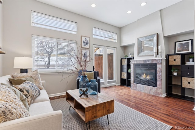 living room featuring dark wood-type flooring, french doors, and a fireplace