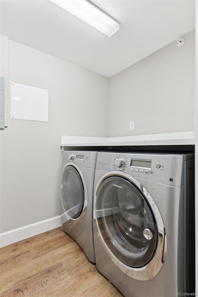 laundry area featuring washer and dryer and light wood-type flooring