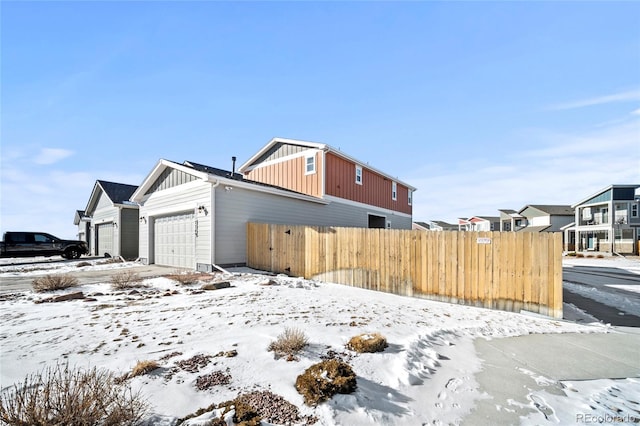 view of snowy exterior featuring a garage