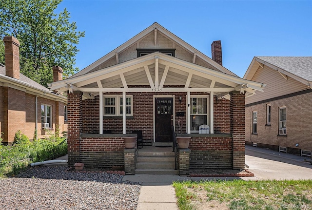 4536 Beach Ct, Denver, CO 80211 - view of front facade featuring a porch, brick siding, and a chimney