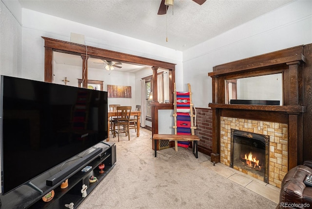 4536 Beach Ct, Denver, CO 80211 - living room featuring a ceiling fan, a textured ceiling, a fireplace with flush hearth, and carpet flooring