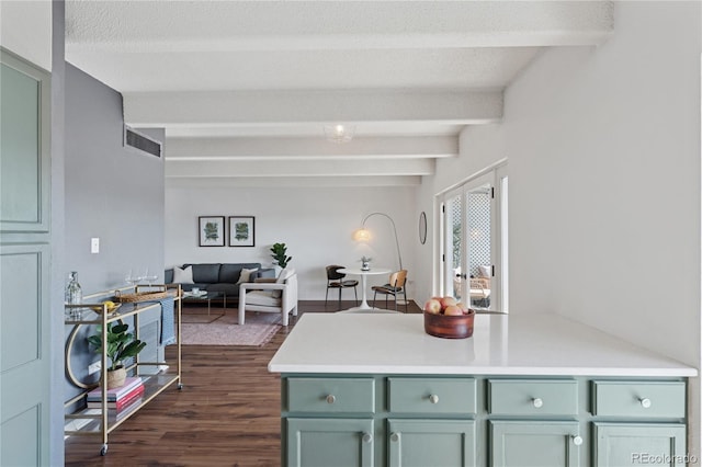 kitchen featuring dark wood finished floors, beamed ceiling, open floor plan, and light countertops