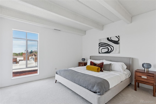 bedroom with beamed ceiling and carpet flooring