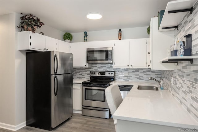 kitchen with white cabinetry, appliances with stainless steel finishes, sink, and decorative backsplash