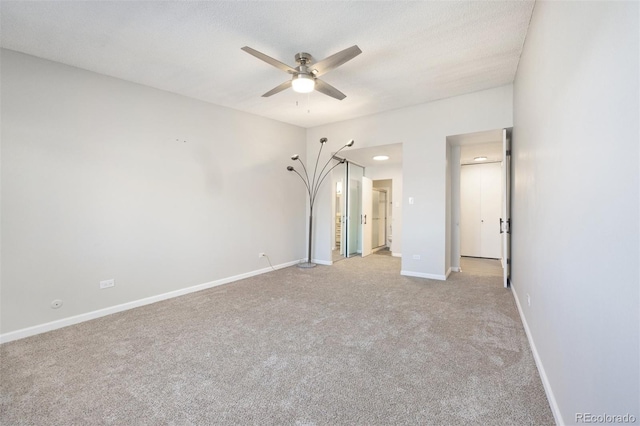 unfurnished bedroom with ceiling fan, light colored carpet, and a textured ceiling