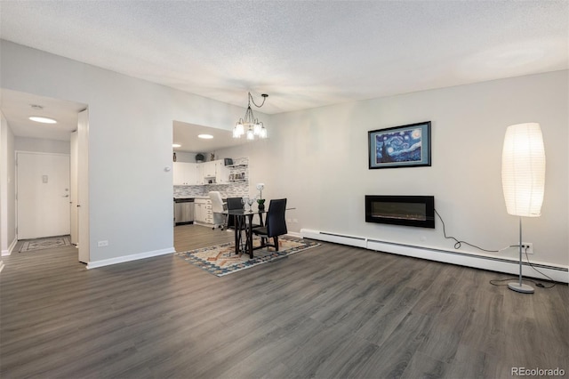 living room with dark hardwood / wood-style flooring, a textured ceiling, an inviting chandelier, and baseboard heating