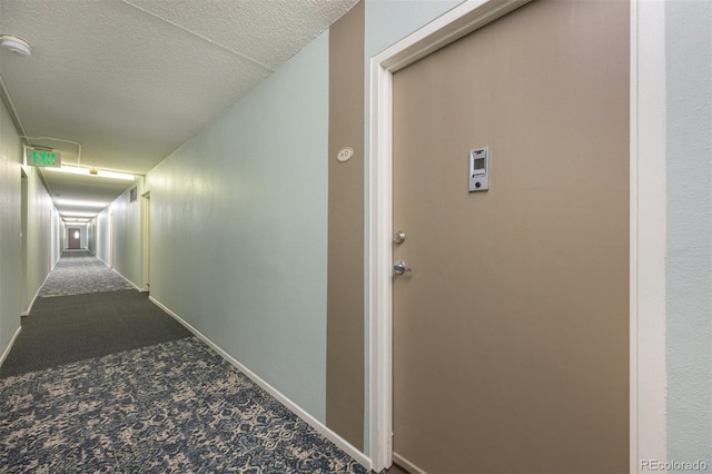 hallway with a textured ceiling and carpet