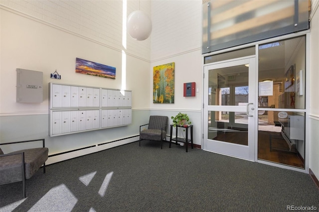 living area with carpet flooring, a mail area, and baseboard heating