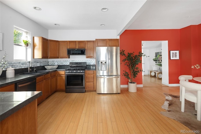 1473 Yates St, Denver, CO 80204 - kitchen with dark countertops, a sink, tasteful backsplash, brown cabinetry, and appliances with stainless steel finishes