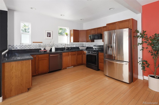 kitchen featuring light hardwood / wood-style flooring, stainless steel appliances, and backsplash