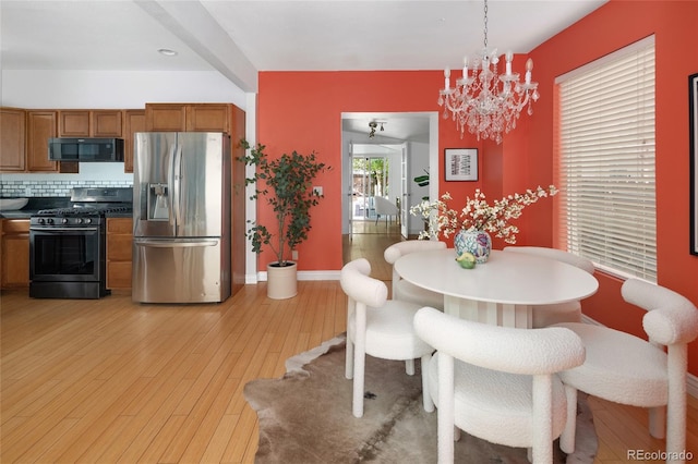 dining area with a notable chandelier and light hardwood / wood-style flooring