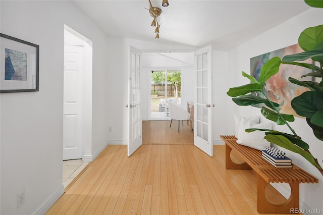 hallway featuring light hardwood / wood-style flooring and french doors