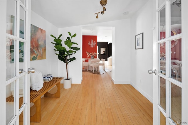 hallway featuring lofted ceiling, french doors, and hardwood / wood-style flooring