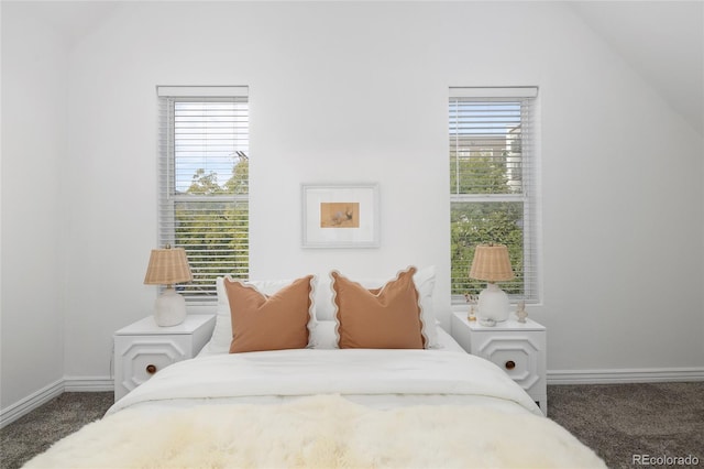 carpeted bedroom with vaulted ceiling and multiple windows