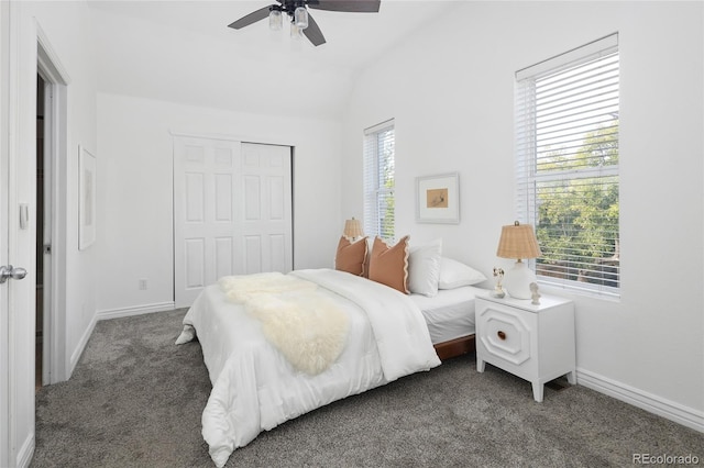 bedroom with dark carpet, a closet, lofted ceiling, and ceiling fan