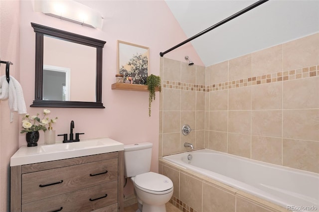 full bathroom with vanity, lofted ceiling, tiled shower / bath combo, and toilet