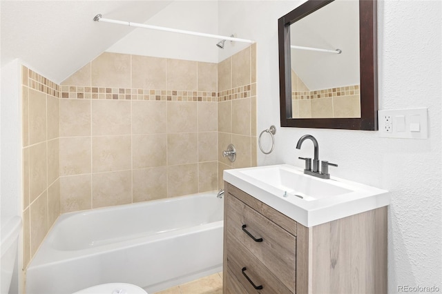 full bathroom with tiled shower / bath, vanity, and toilet