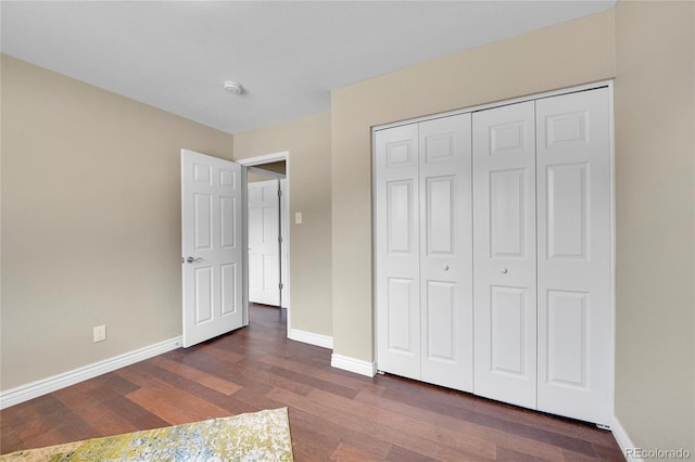 unfurnished bedroom with a closet and dark wood-type flooring