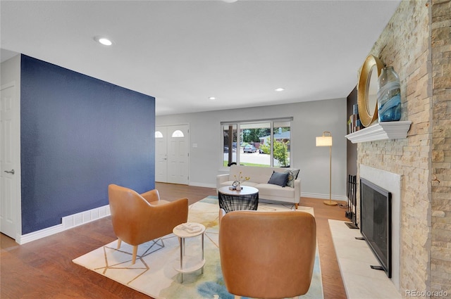 living room featuring light hardwood / wood-style floors and a stone fireplace