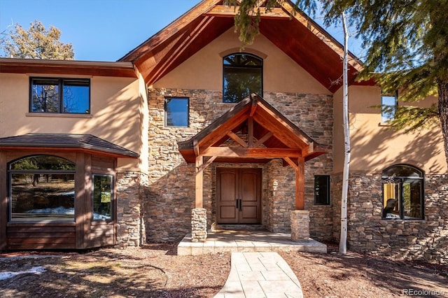 view of front facade with stone siding and stucco siding