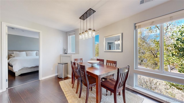 dining room with dark hardwood / wood-style floors and a notable chandelier