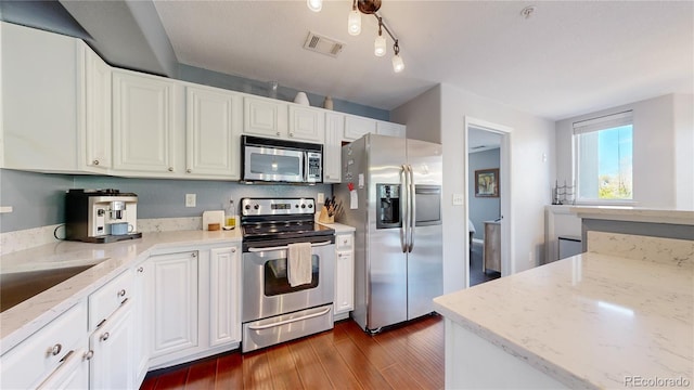 kitchen featuring stainless steel appliances, dark hardwood / wood-style flooring, light stone countertops, and white cabinets