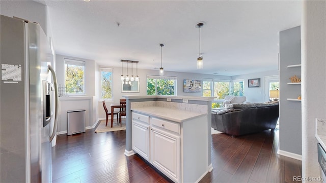 kitchen featuring a kitchen island, dark hardwood / wood-style floors, white cabinets, hanging light fixtures, and stainless steel fridge with ice dispenser