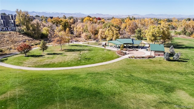 view of home's community with a mountain view and a lawn