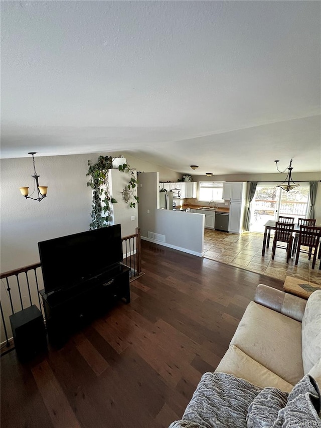 living room featuring dark hardwood / wood-style floors and an inviting chandelier