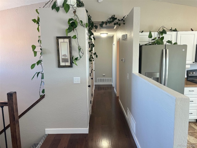 corridor featuring dark hardwood / wood-style floors and vaulted ceiling