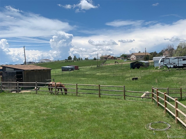 view of yard featuring a rural view and an outdoor structure