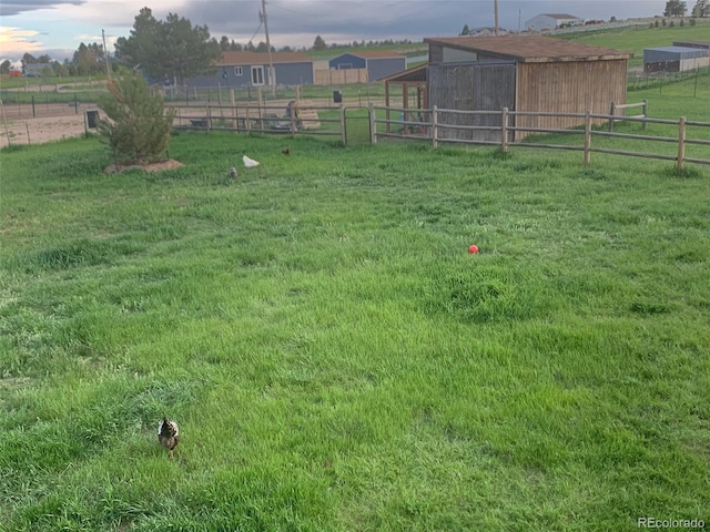 view of yard with an outbuilding and a rural view