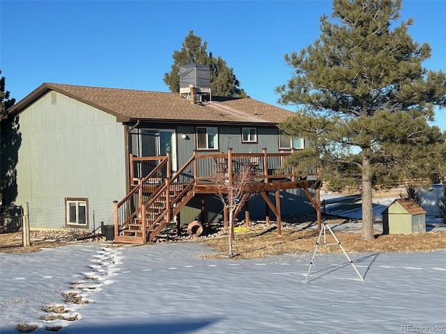 snow covered house featuring a wooden deck