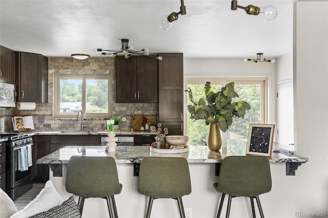 6254 W 79th Ave, Arvada, CO 80003 - kitchen featuring stainless steel appliances, a breakfast bar area, and healthy amount of natural light