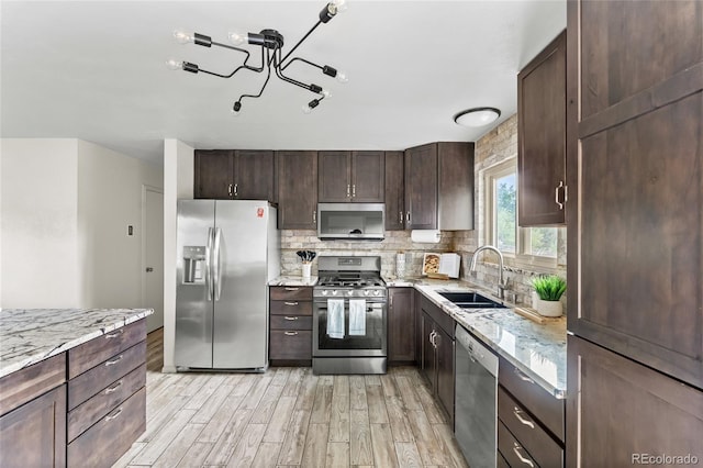6254 W 79th Ave, Arvada, CO 80003 - kitchen with stainless steel appliances, light wood finished floors, dark brown cabinets, and tasteful backsplash