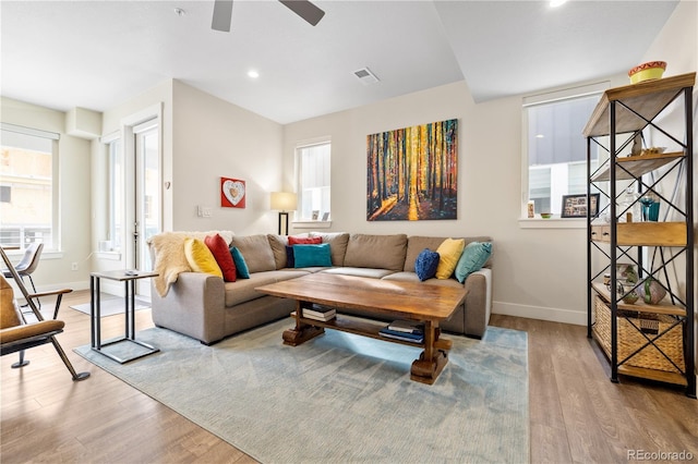living room featuring baseboards, ceiling fan, plenty of natural light, and wood finished floors