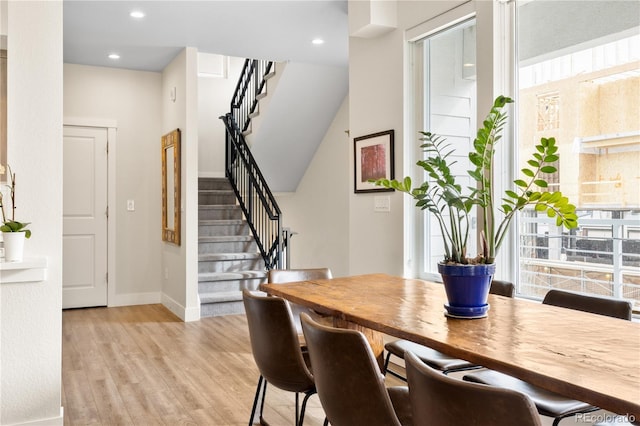 dining room featuring baseboards, light wood-style flooring, stairs, and recessed lighting