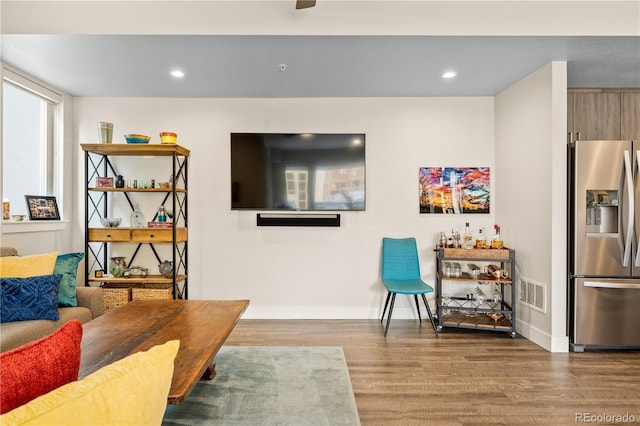 living room featuring baseboards, recessed lighting, wood finished floors, and visible vents