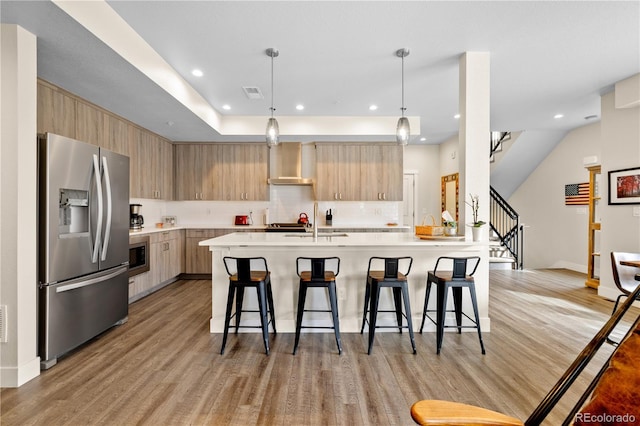 kitchen featuring wall chimney range hood, modern cabinets, and stainless steel appliances