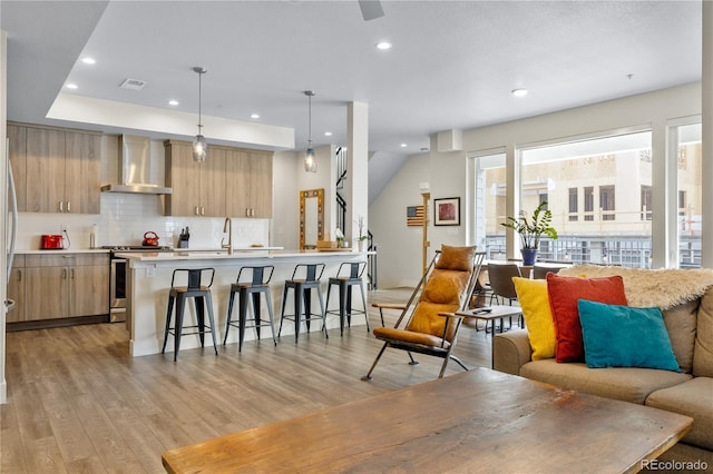 living area with recessed lighting, light wood finished floors, ceiling fan, and visible vents